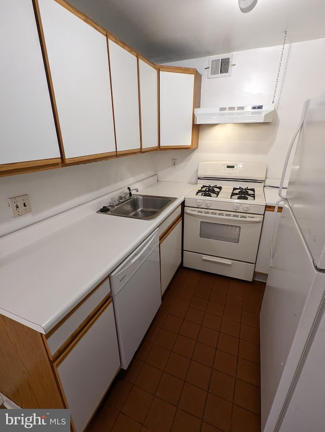 kitchen featuring sink, white appliances, and white cabinetry