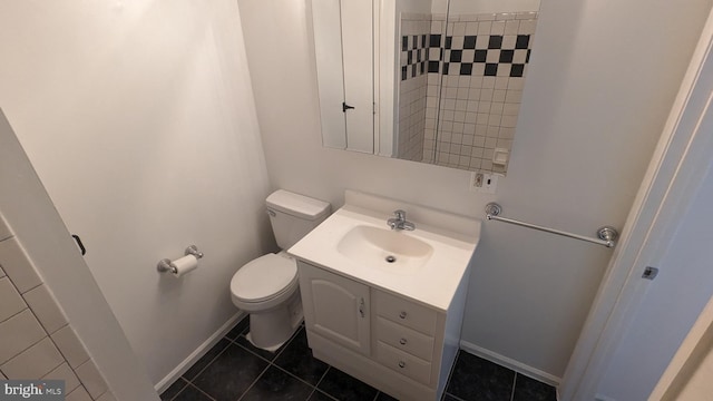 bathroom with toilet, vanity, and tile patterned floors