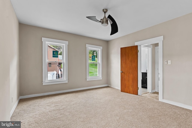 unfurnished bedroom featuring light colored carpet and ceiling fan