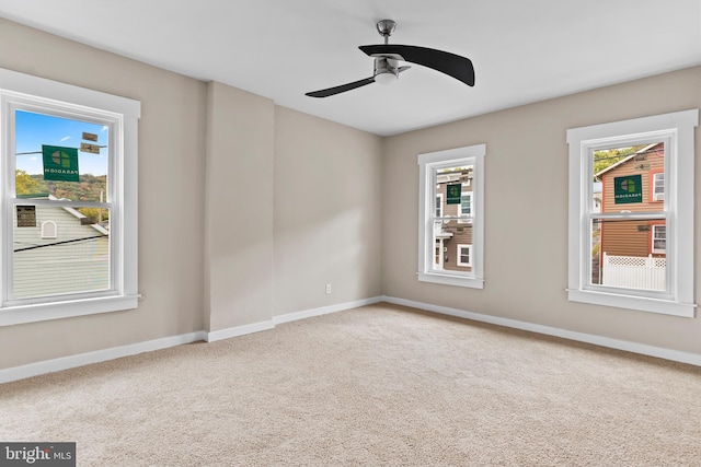 spare room featuring carpet floors, a wealth of natural light, and ceiling fan