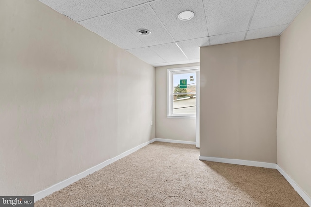 carpeted spare room with a paneled ceiling