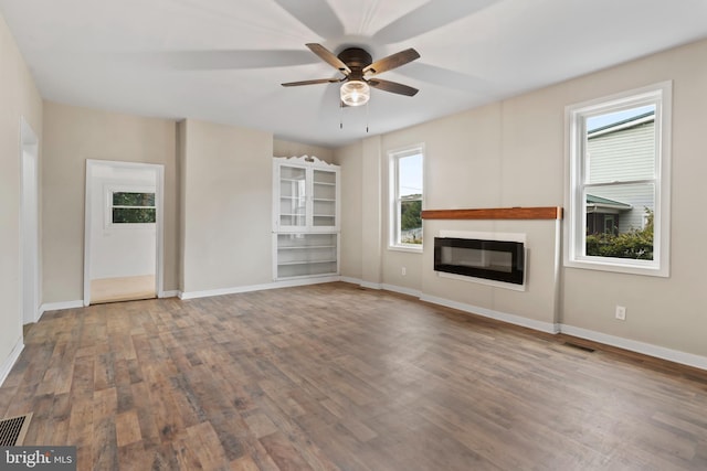 unfurnished living room featuring hardwood / wood-style flooring, plenty of natural light, and ceiling fan