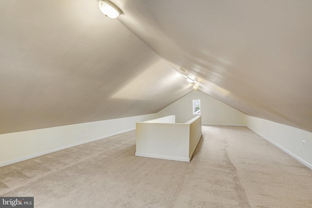 additional living space with vaulted ceiling and light colored carpet