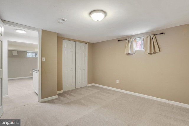 unfurnished bedroom featuring light carpet and a closet