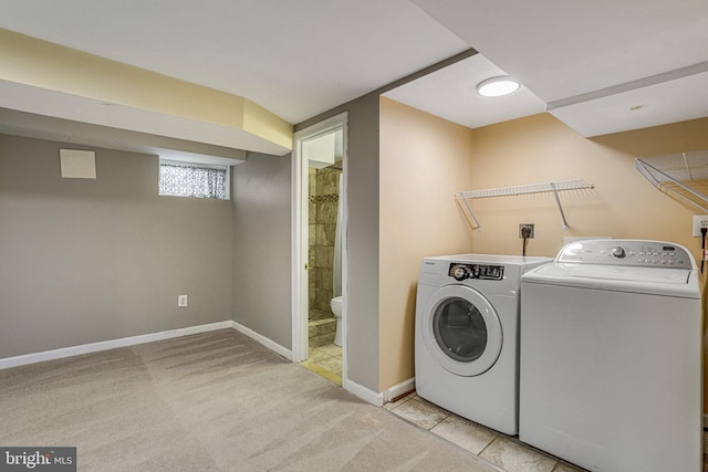 laundry room with washing machine and clothes dryer and light carpet