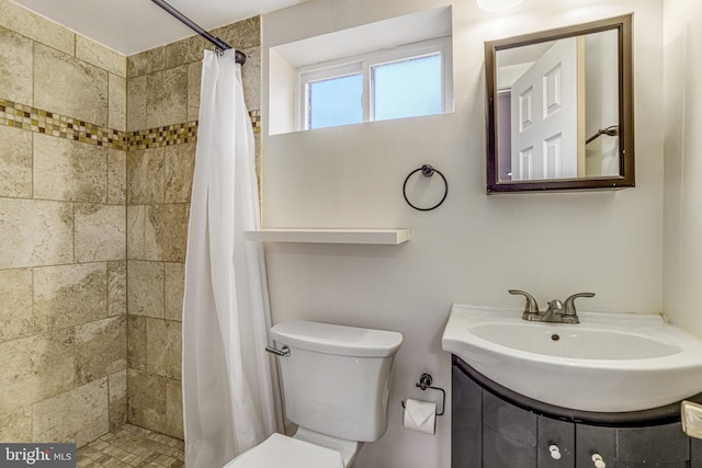 bathroom with vanity, curtained shower, and toilet