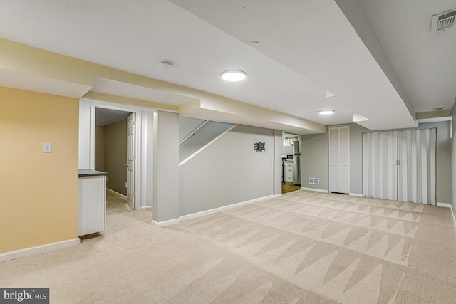 basement featuring light carpet