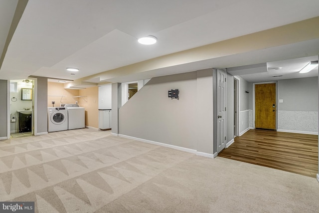 basement with washing machine and clothes dryer and light carpet