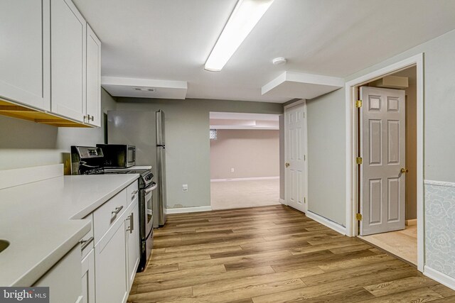 kitchen featuring white cabinetry, stainless steel range, and light hardwood / wood-style floors