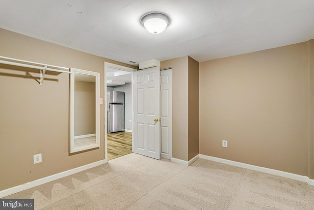 unfurnished bedroom featuring stainless steel refrigerator and carpet floors