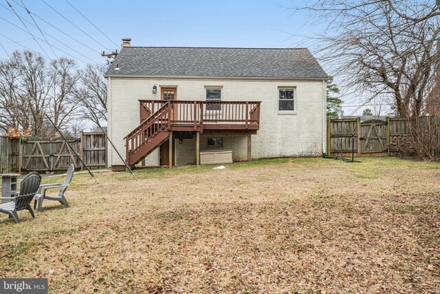 rear view of property with a wooden deck and a lawn