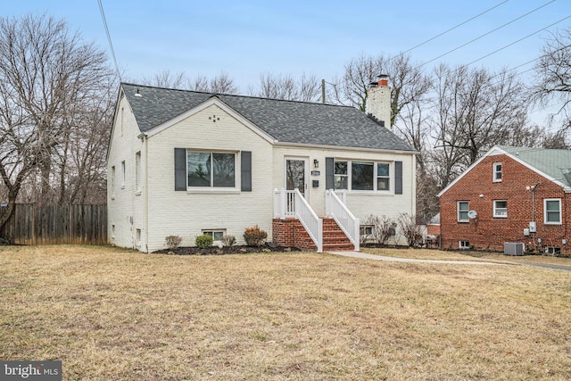 bungalow featuring cooling unit and a front lawn