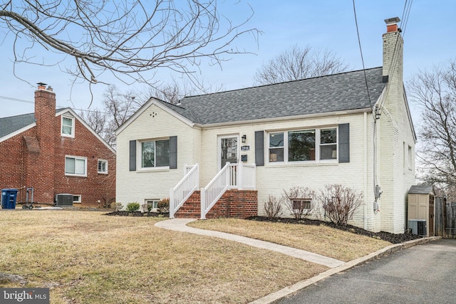 view of front of house featuring cooling unit and a front yard