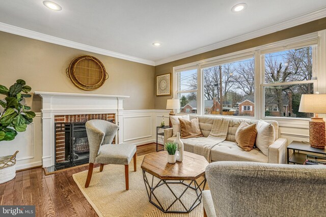 living room with a brick fireplace, crown molding, and dark hardwood / wood-style floors