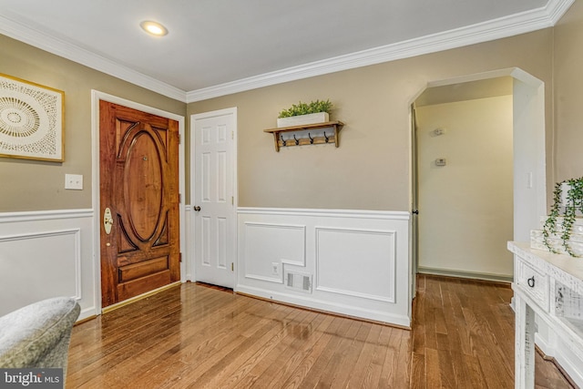 foyer entrance featuring hardwood / wood-style flooring and ornamental molding