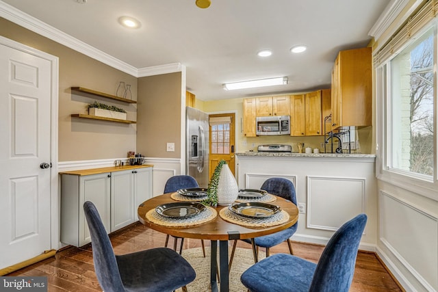 dining room with ornamental molding, a wealth of natural light, and dark hardwood / wood-style flooring