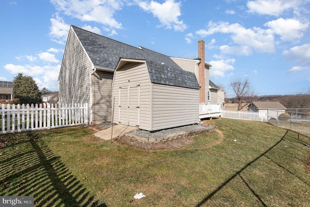 back of property with a storage shed and a yard