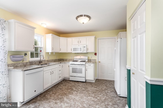 kitchen with sink, white appliances, light stone countertops, and white cabinets