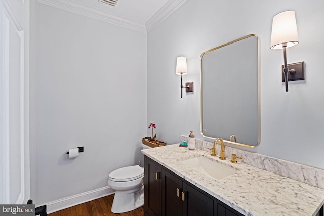 bathroom featuring vanity, crown molding, toilet, and hardwood / wood-style flooring