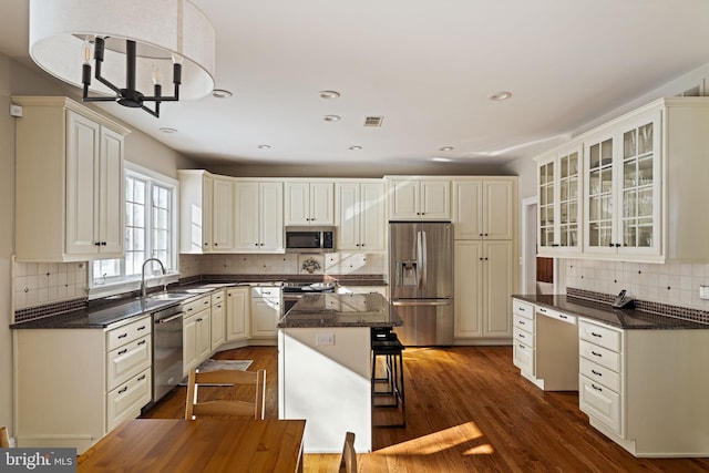 kitchen featuring dark wood-type flooring, a breakfast bar, sink, a kitchen island, and stainless steel appliances