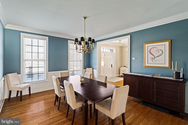 dining room with wood-type flooring, a notable chandelier, and crown molding