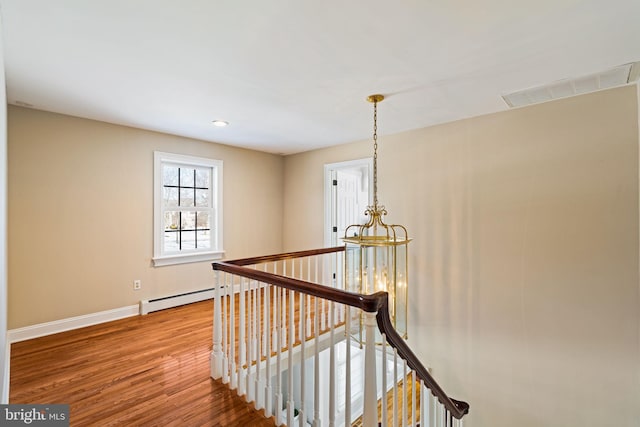 hallway with baseboard heating and hardwood / wood-style floors