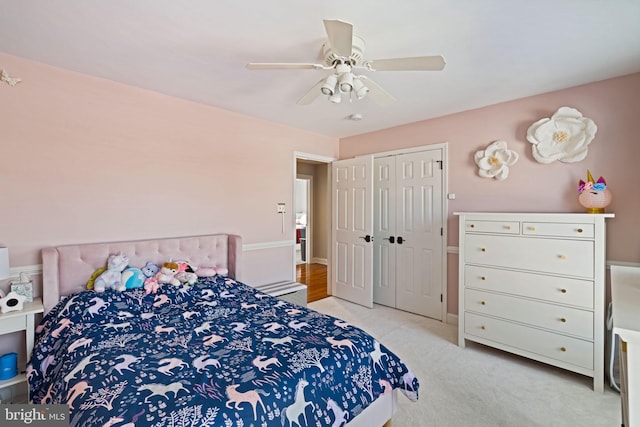 carpeted bedroom with ceiling fan and a closet