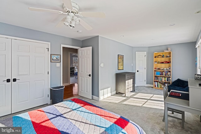 carpeted bedroom with ceiling fan and a closet