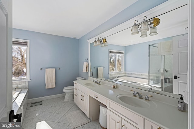 bathroom with a relaxing tiled tub, vanity, toilet, and tile patterned flooring