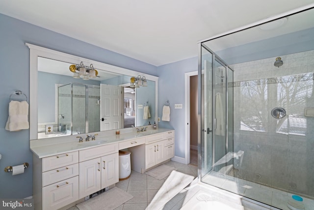 bathroom featuring tile patterned flooring, vanity, and a shower with shower door