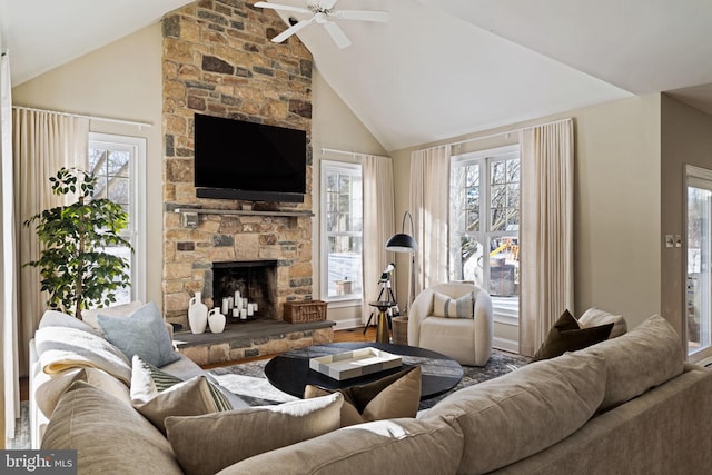 living room featuring ceiling fan, high vaulted ceiling, a healthy amount of sunlight, and a fireplace