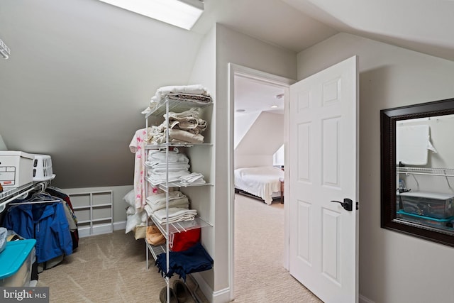 walk in closet featuring vaulted ceiling and light carpet