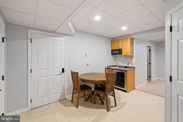 dining area featuring wine cooler and a drop ceiling