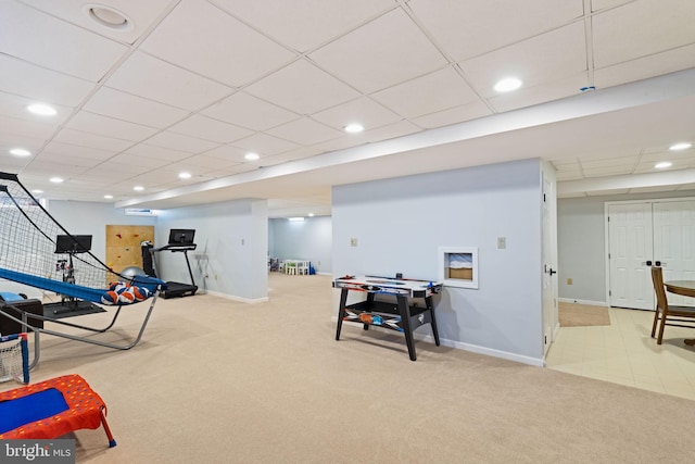 exercise area with a paneled ceiling and light colored carpet