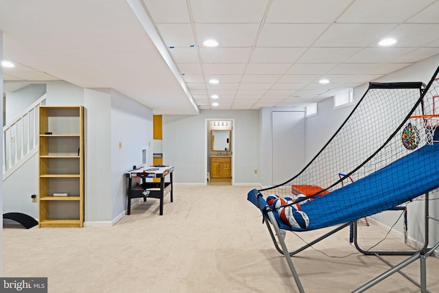 rec room featuring light carpet and a drop ceiling