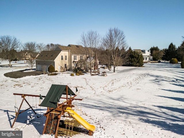 snow covered house with a playground