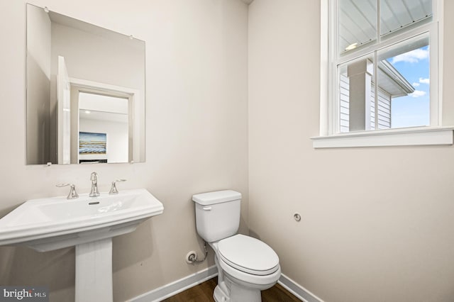 bathroom with toilet, hardwood / wood-style floors, and sink