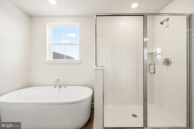 bathroom featuring shower with separate bathtub