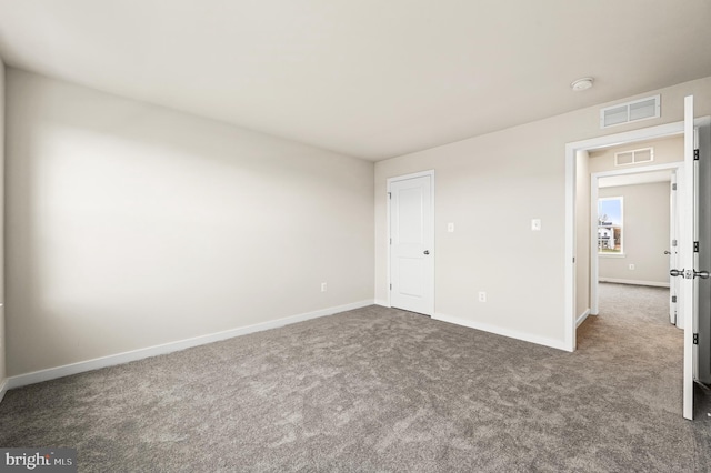 unfurnished room featuring dark colored carpet