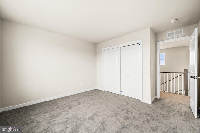 unfurnished bedroom featuring carpet floors and a closet