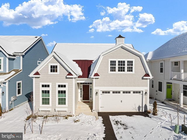 view of front of house featuring driveway, an attached garage, and a gambrel roof