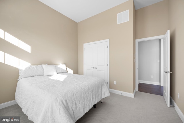 carpeted bedroom featuring high vaulted ceiling and a closet