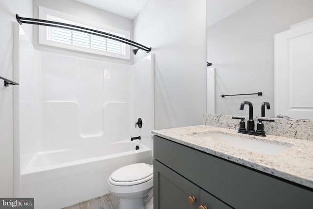 full bath featuring shower / bathtub combination, toilet, wood finished floors, and vanity