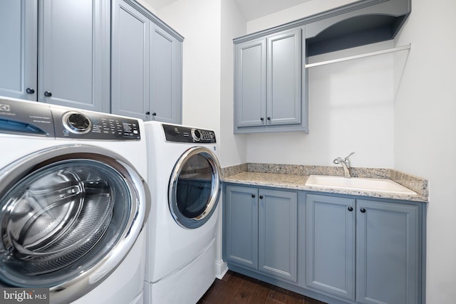 laundry room featuring cabinet space, dark wood-style flooring, separate washer and dryer, and a sink