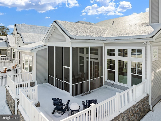 rear view of property with a sunroom and a shingled roof