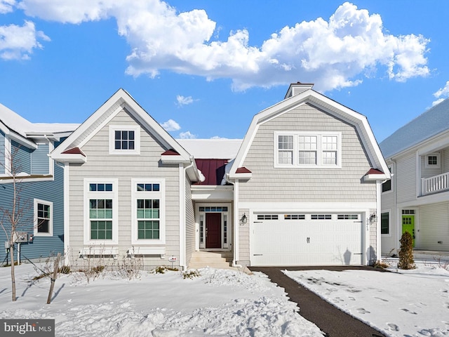 view of front of house with metal roof, aphalt driveway, an attached garage, a gambrel roof, and a standing seam roof