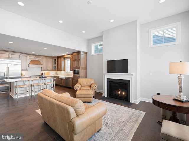 living room with a fireplace with flush hearth, recessed lighting, dark wood-style flooring, and baseboards