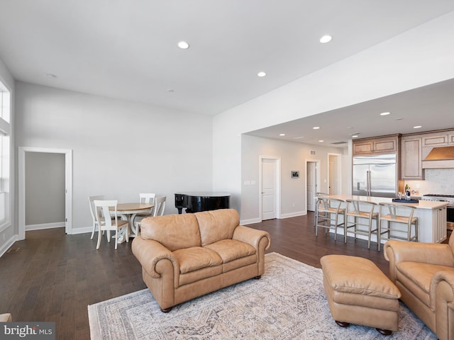 living room featuring baseboards, dark wood finished floors, and recessed lighting