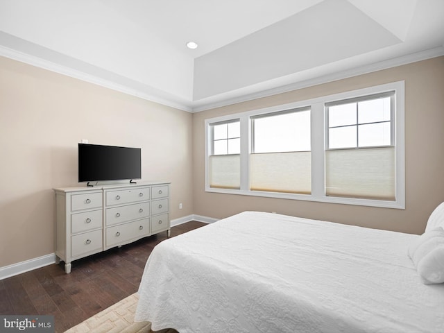 bedroom with dark wood-type flooring, a raised ceiling, and baseboards