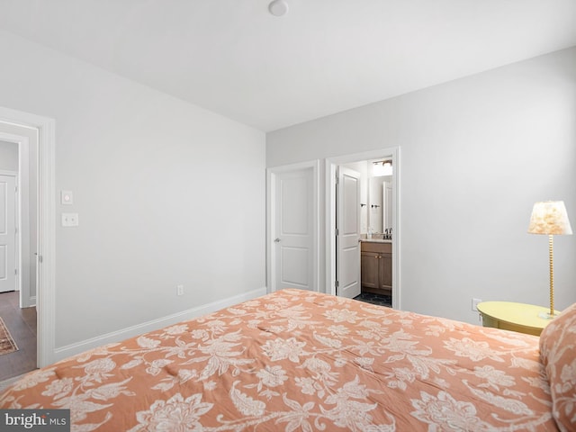 unfurnished bedroom featuring ensuite bath and baseboards